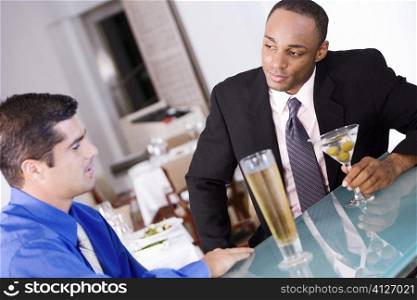 Close-up of two businessmen sitting at a bar counter