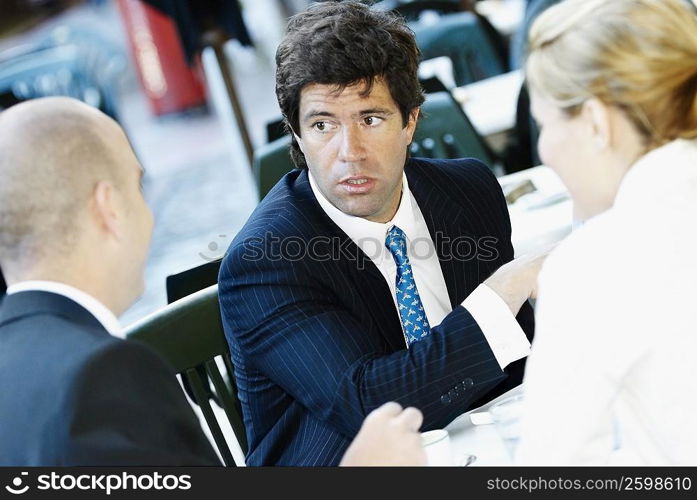 Close-up of two businessmen sitting with a businesswoman