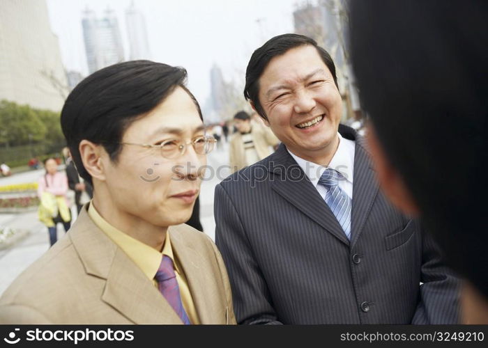 Close-up of two businessmen smiling