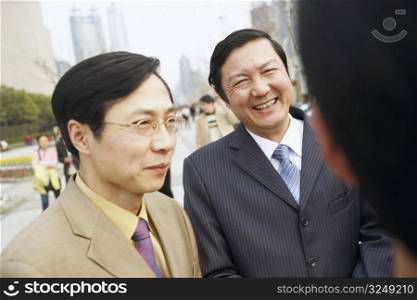 Close-up of two businessmen smiling
