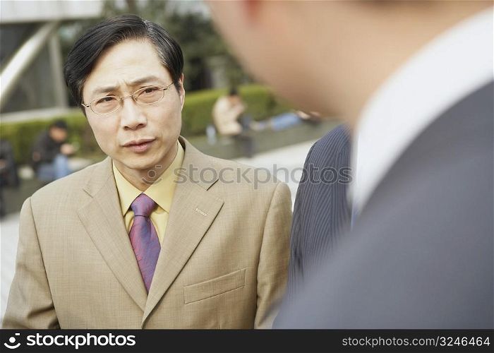 Close-up of two businessmen standing face to face