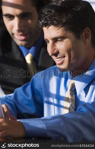 Close-up of two businessmen using a laptop