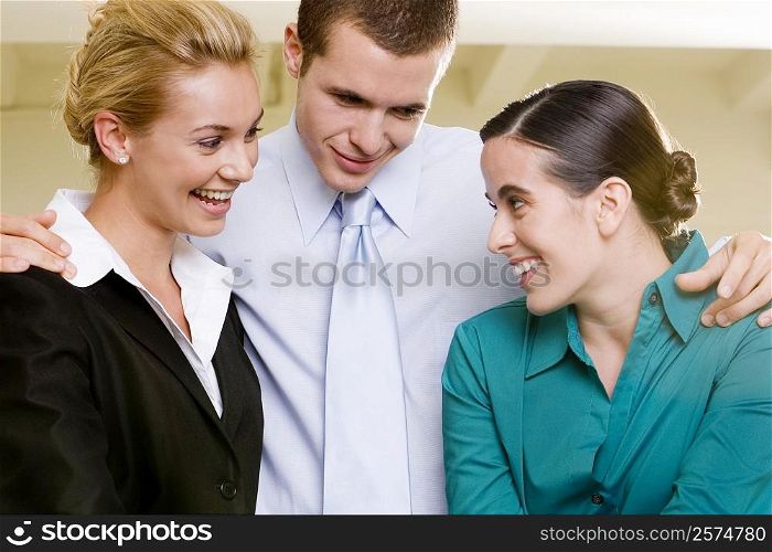 Close-up of two businesswomen and a businessman smiling