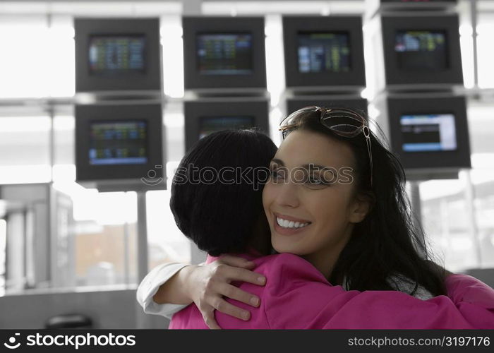 Close-up of two businesswomen hugging each other at an airport