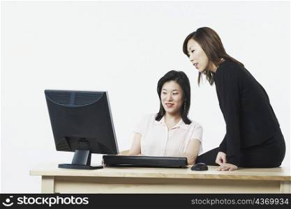 Close-up of two businesswomen looking at a computer