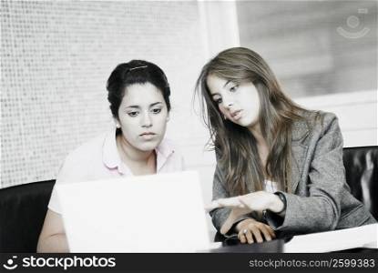 Close-up of two businesswomen looking at a laptop