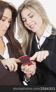 Close-up of two businesswomen looking at a mobile phone