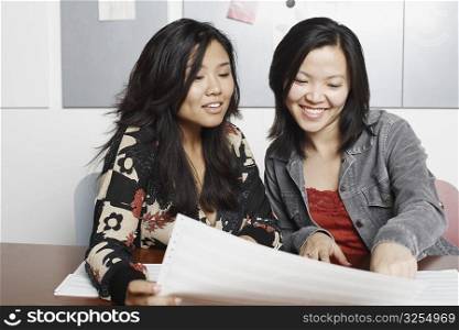 Close-up of two businesswomen reading documents