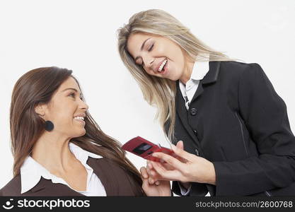 Close-up of two businesswomen smiling and holding a mobile phone