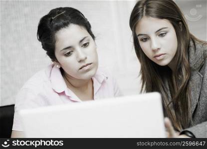 Close-up of two businesswomen using a laptop