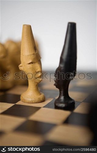 Close-up of two chess pieces on a chessboard