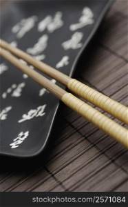 Close-up of two chopsticks and a tray