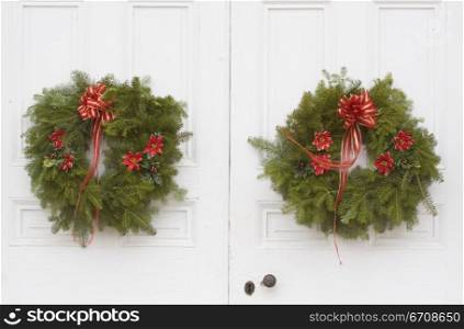 Close-up of two Christmas wreaths on the door