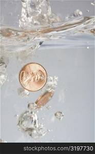 Close-up of two coins in water