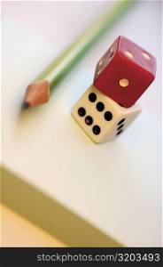Close-up of two dices with a pencil