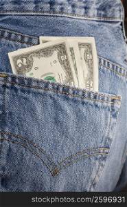 Close-up of two dollar bills in the pocket of a pair of jeans