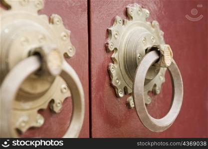 Close-up of two doorknockers on a door