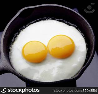 Close-up of two eggs cooking in a frying pan