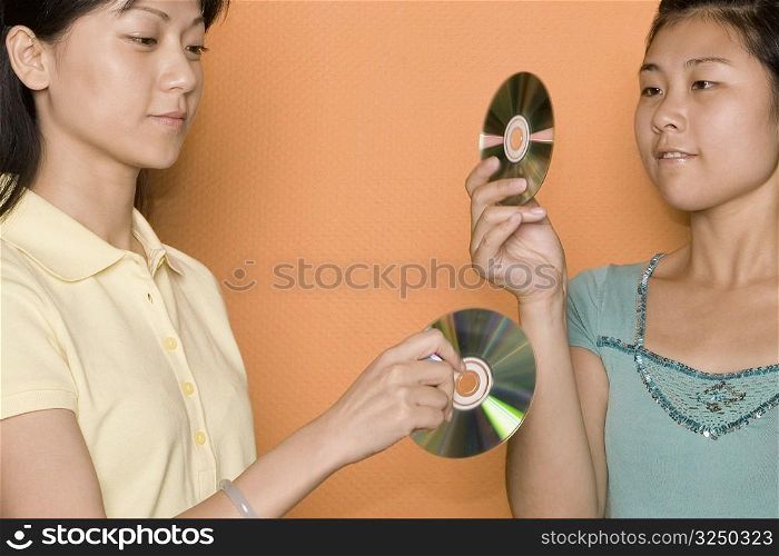 Close-up of two female workers looking at CDs