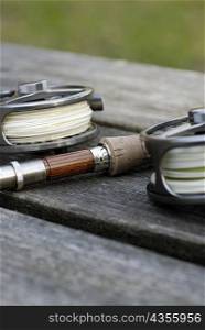 Close-up of two fishing reels and a fishing rod