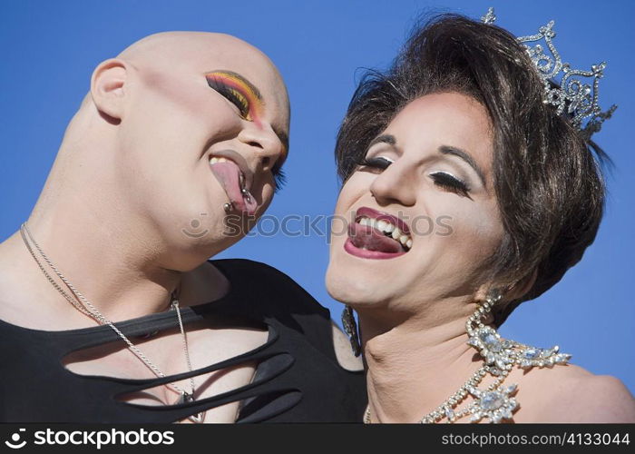 Close-up of two gay men sticking out their tongues