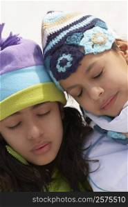 Close-up of two girls with their eyes closed