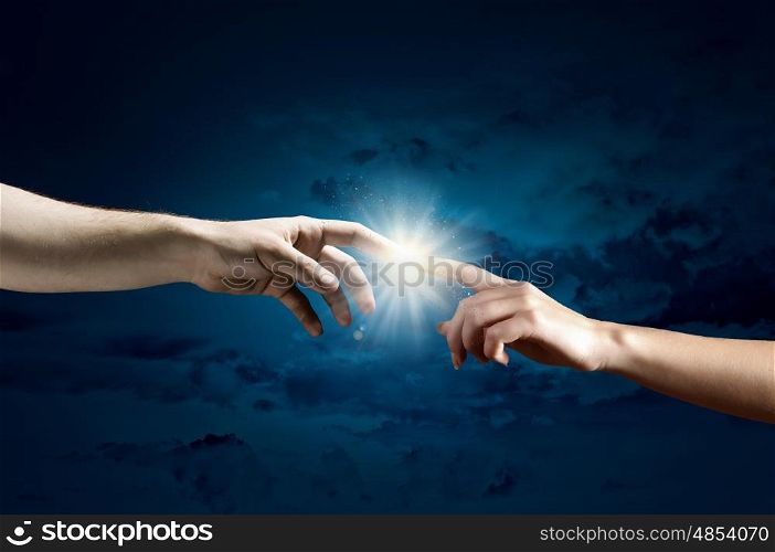 Close up of two hands reaching each other with fingers