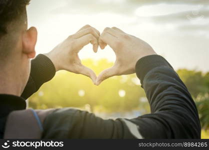 Close up of two hands together in a heart shape, hands together in a heart shape, young man putting fingers together in a heart shape