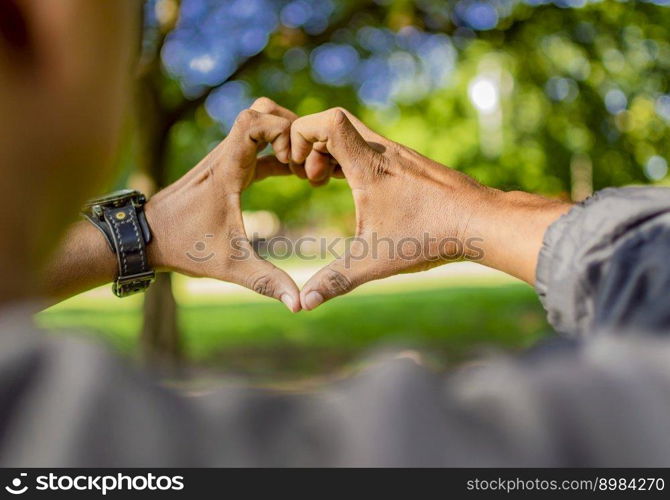 Close up of two hands together in a heart shape, hands together in a heart shape, young man putting fingers together in a heart shape