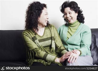 Close-up of two mature women looking at each other smiling