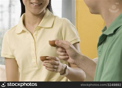 Close-up of two office workers holding tea cups