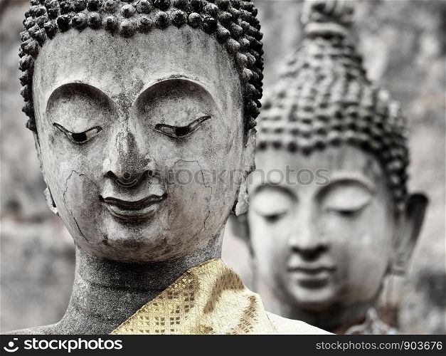 Close-up of two old Buddha statues of the ruined ancient temple at Ayutthaya