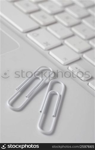 Close-up of two paper clips on a laptop