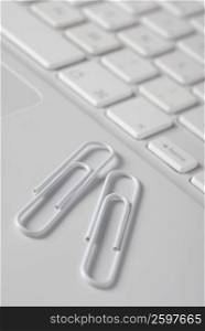 Close-up of two paper clips on a laptop