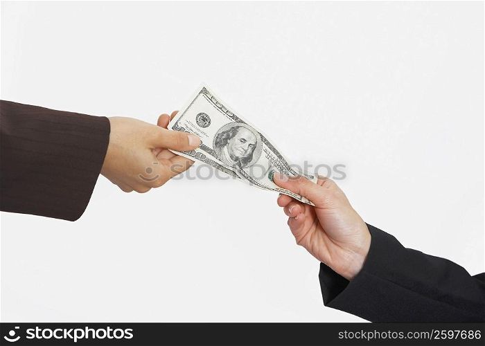 Close-up of two people&acute;s hands holding American paper currency