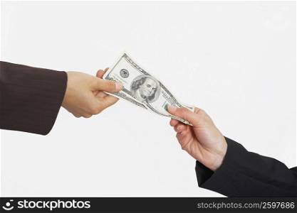 Close-up of two people&acute;s hands holding American paper currency