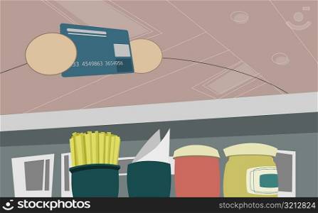 Close-up of two people holding a credit card at a checkout counter