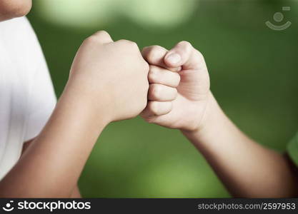 Close-up of two people with their fists touching