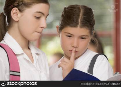 Close-up of two schoolgirls looking at a textbook