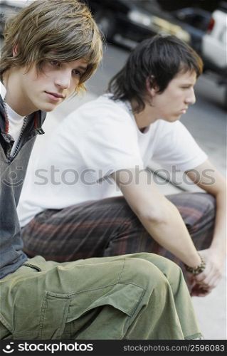 Close-up of two teenage boys sitting together