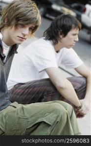 Close-up of two teenage boys sitting together