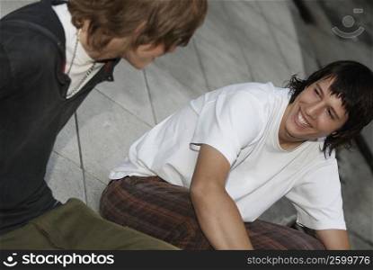 Close-up of two teenage boys sitting together and smiling