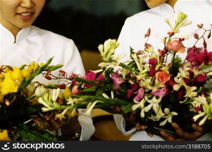 Close-up of two teenage girls holding flowers, Hong Kong, China