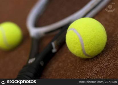 Close-up of two tennis balls and a tennis racket