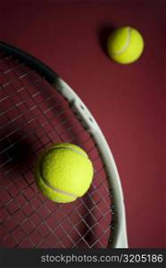 Close-up of two tennis balls and a tennis racket