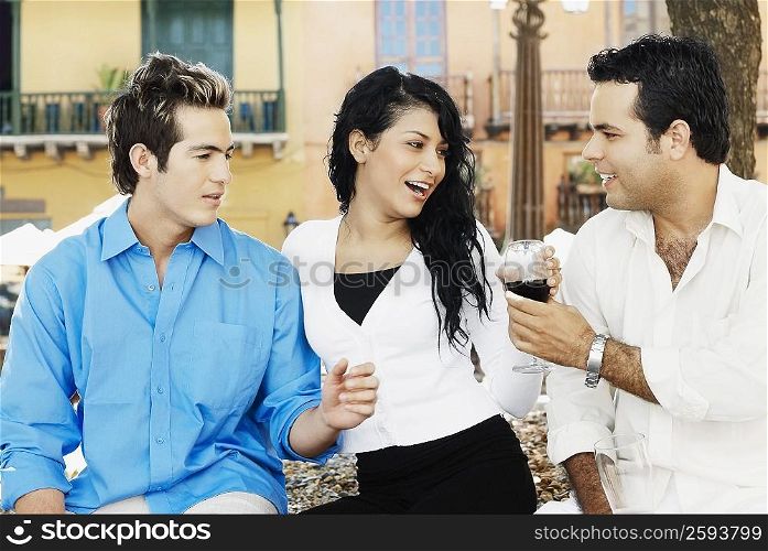 Close-up of two young men and a young woman smiling