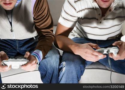 Close-up of two young men playing video game