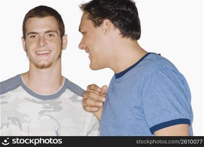 Close-up of two young men talking to each other