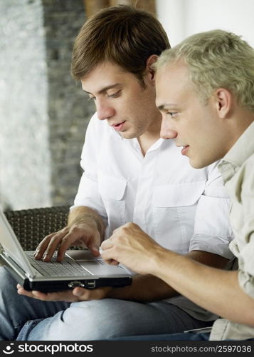 Close-up of two young men using a laptop