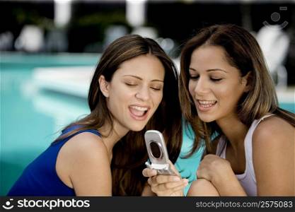 Close-up of two young women holding a mobile phone